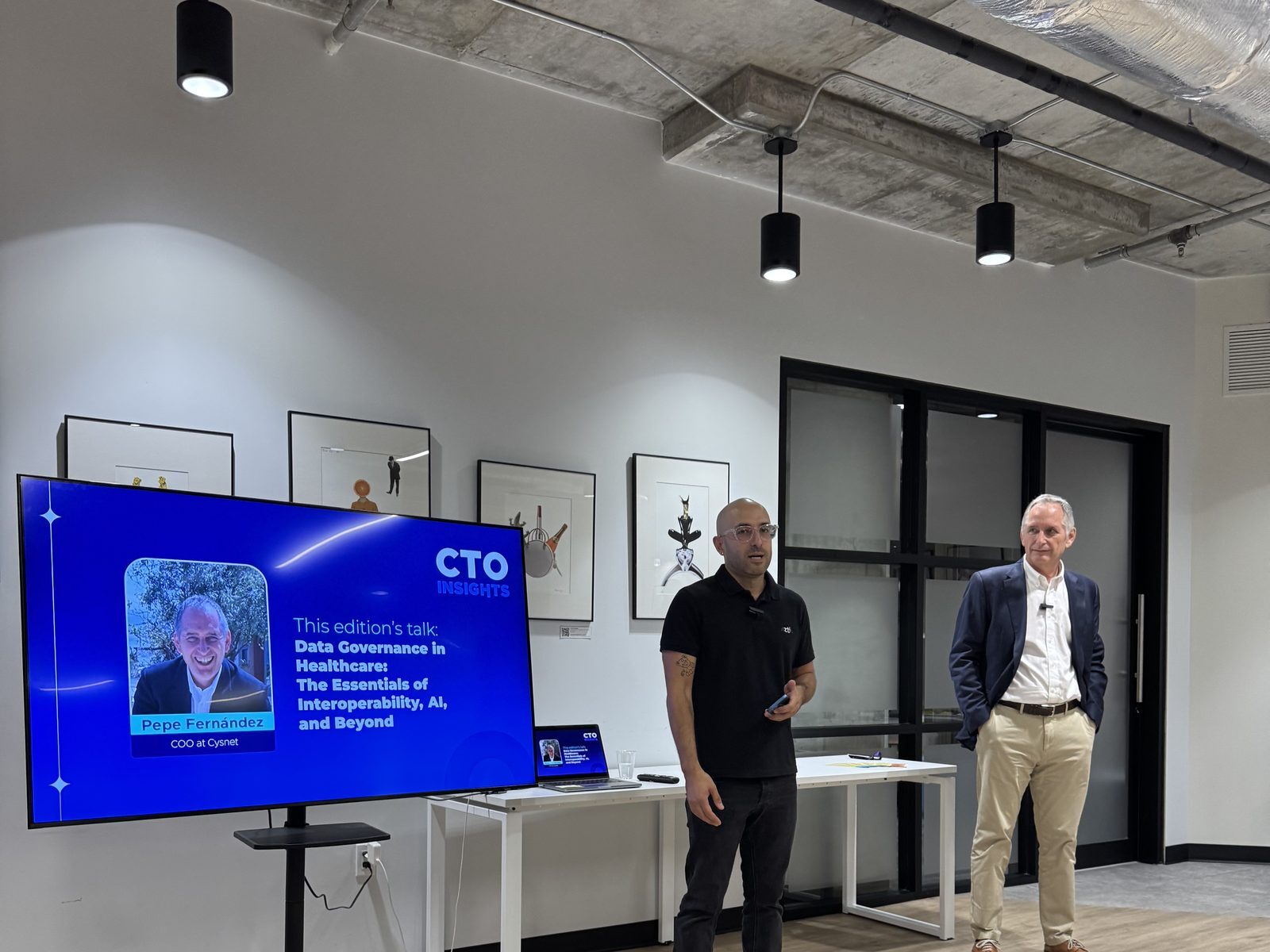 Sala de CTO Insights Miami con dos ponentes junto a la pantalla del evento